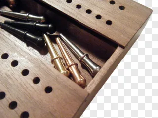 A wooden box containing brass and steel bullet tips on a transparent background.