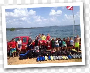 A scuba diver group posing by a lake with diving gear on a transparent background.