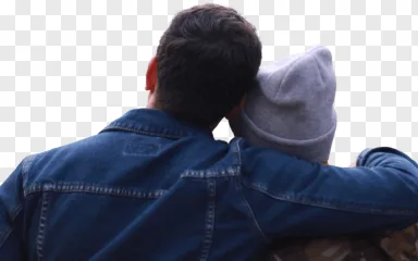 A couple embracing from behind, with the man wearing a denim jacket and the woman a beanie, on a transparent background.