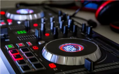 A professional DJ controller audio mixer with glowing lights on a transparent background.