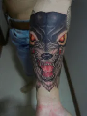 A fierce wolf tattoo on an arm is shown on a transparent background.