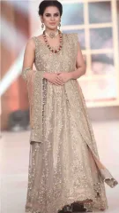 Woman wearing a beige embroidered anarkali suit on a transparent background.