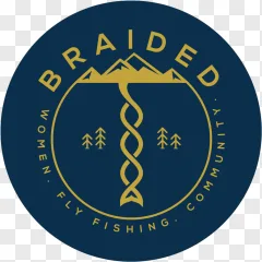 A women fly fishing community logo designed as a bold graphic emblem with gold mountains and trees on a transparent background.